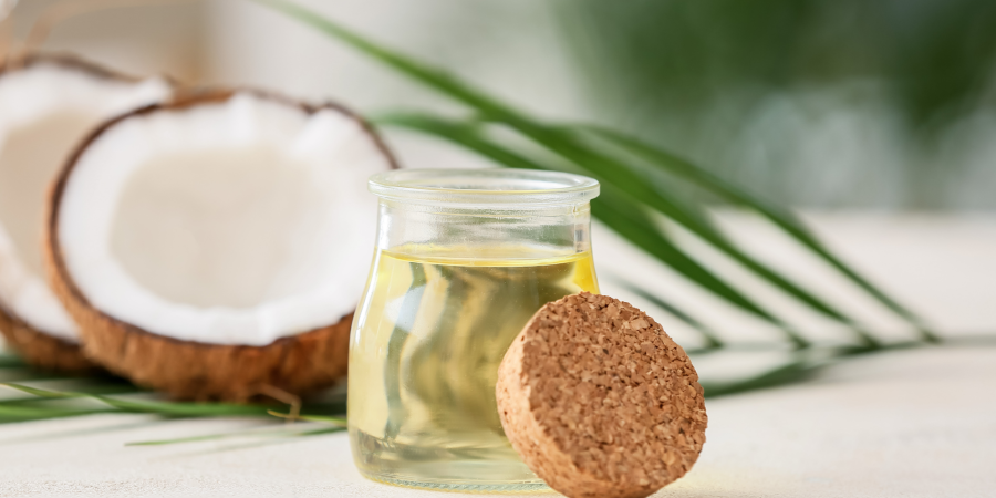 coconut oil in a jar with coconuts in the background