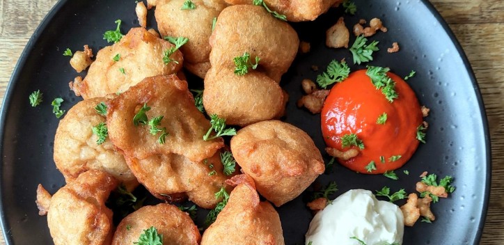 Akara bites on a plate with garnish and dips