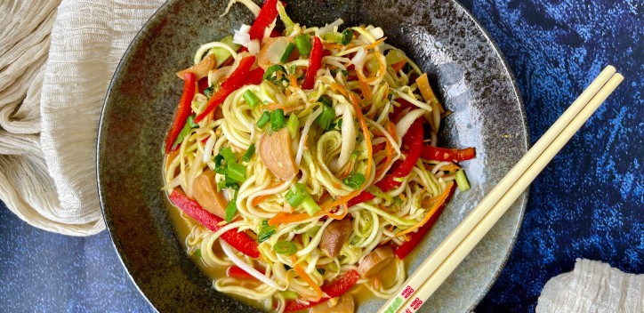Raw vegan chow mein served at a table with chopsticks