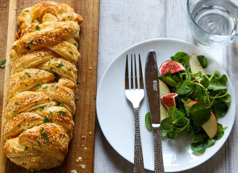 Paprika mustard leek and tofu plait next to a plate with salad.