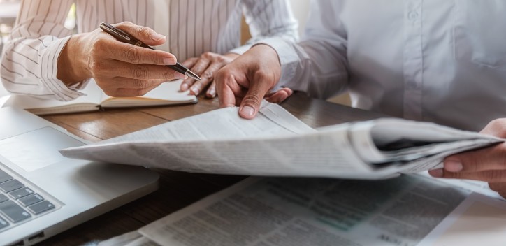 Two people reading newspapers