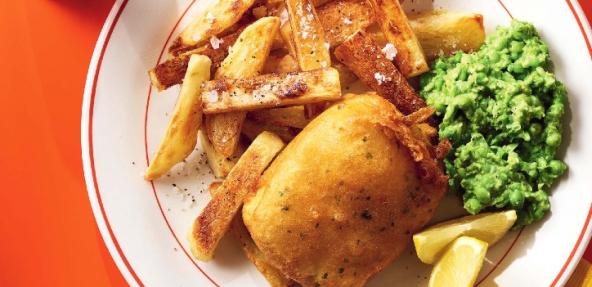 to'fish and chips served on a plate with peas and a wedge of lemon