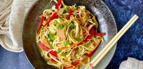 Raw vegan chow mein served at a table with chopsticks