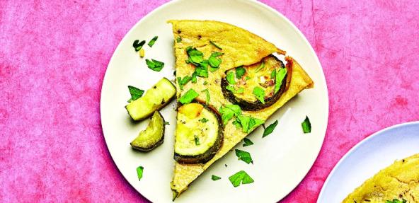 photograph of courgette and aubergine farinata on a plate against a pink bakground