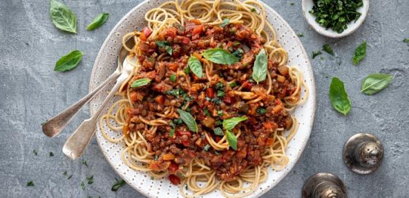 Lentil Bolognese served on a plate with fresh herbs