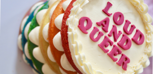 Vegan rainbow cake with 'loud and queer' icing on the front