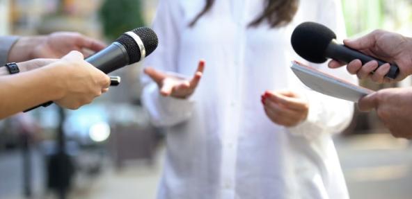 People holding microphones interviewing a spokesperson
