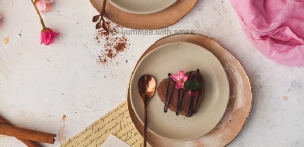 Mocha panna cotta hearts served on a dish with edible flowers