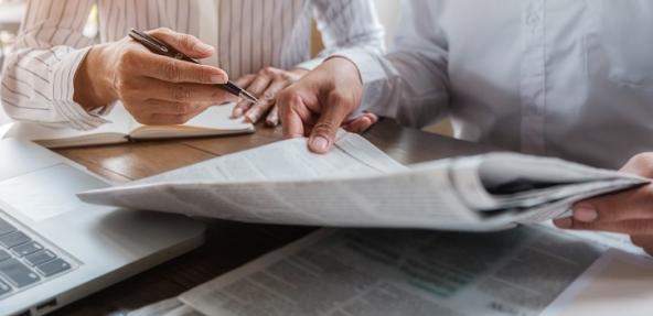 Two people reading newspapers
