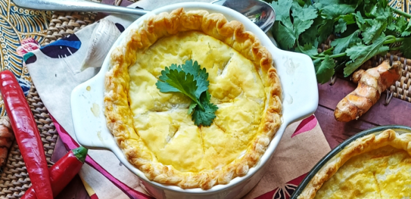 Opor Nangka (Jackfruit Coconut Pot Pie) served on a dressed table surrounded by chilli's and garnishes