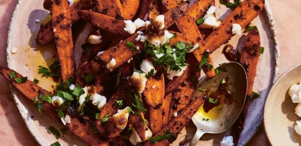 photograph of sweet and sticky jerk roasted carrots with vegan feta on a plate