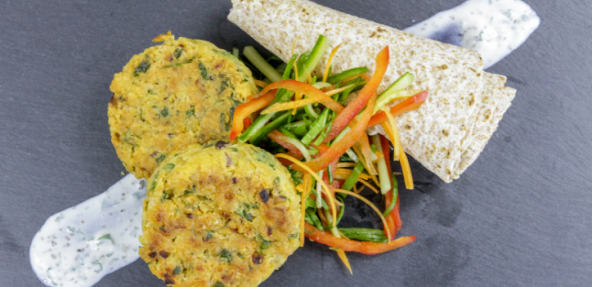 Chickpea and coriander patties on a dark slate background with shredded vegetables