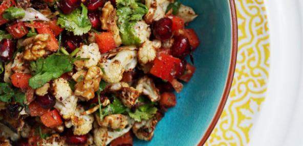 Vegan cauliflower sumac salad with pomegranate seeds, walnuts and red peppers served in a bowl