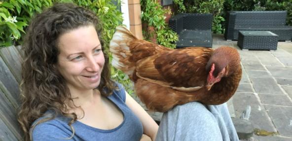 Charlotte with rescued hen on their knee
