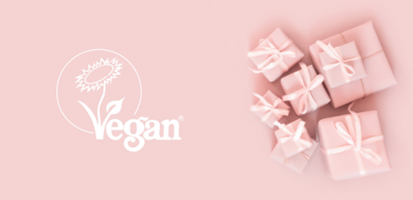 Pink gift boxes against a pink background with the Vegan Trademark sunflower logo on white