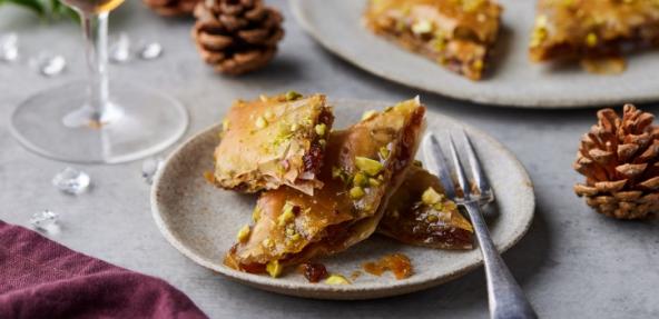 mincemeat baklava on a plate presented on a festive table with pine cones and decorations