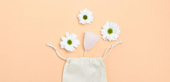 menstrual cup with canvas bag and flowers