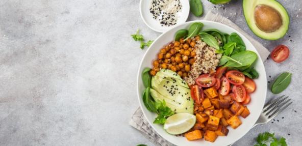 Healhty vegan lunch bowl. Avocado, quinoa, sweet potato, tomato, spinach and chickpeas vegetables salad