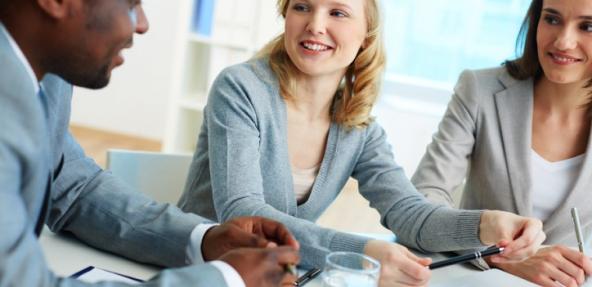 Three smiley people in office meeting