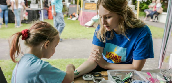 child painting on someone's arm