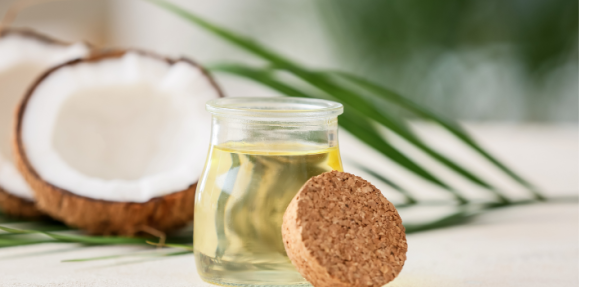 Coconut oil in a jar with coconuts in the background