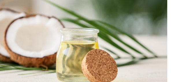 Coconut oil in a jar with coconuts in the background