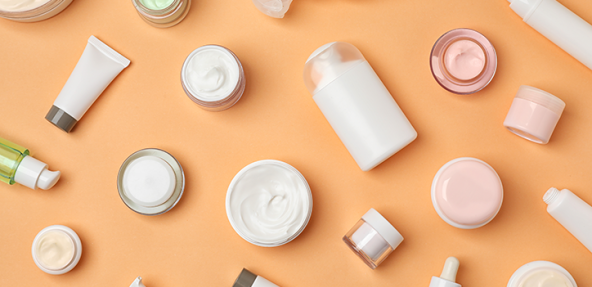 plain cosmetic bottles laid out against an orange background