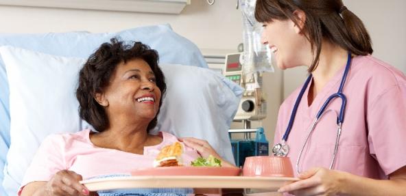 lady in hospital bed talking to a nurse