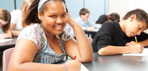 School girl smiling at a school desk 