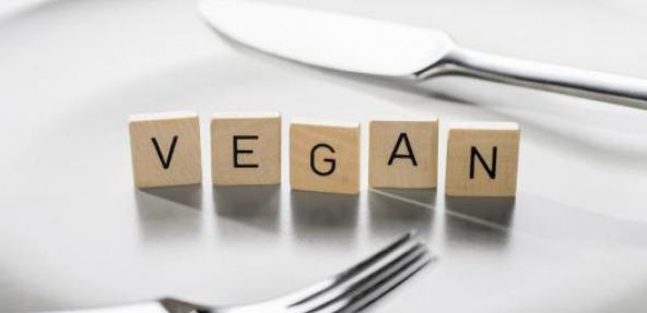 Vegan scrabble tiles on a white plate with knife and fork