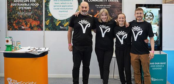Four Vegan Society members of staff at an event stall.
