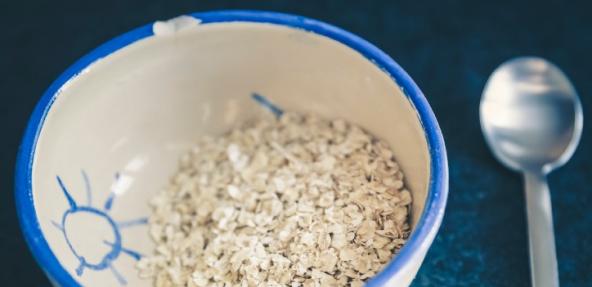 A patterned bowl of oats on a table with a spoon on the side.  Image by Markus Spiske on Unsplash
