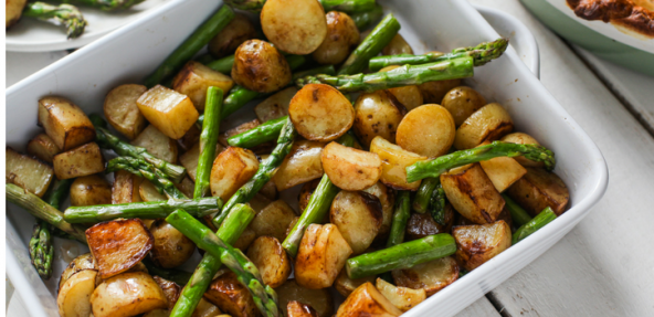 A square dish filled with roasted new potatoes and asparagus.