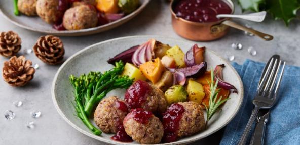 nut patties with orange sauce surrounded by pine cones and holly