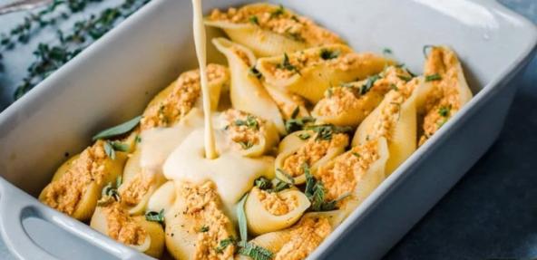 Photograph of vegan pumpkin ricotta stuffed shells being served in a dish