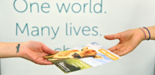 Hands exchanging a Vegan Society leaflet