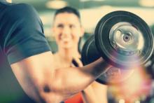 Person holding a weight with a personal trainer