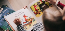 child reading a story book about a fox