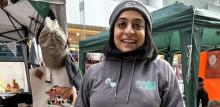 Photograph of Poonam wearing Lola's sanctuary merchandise outside a market