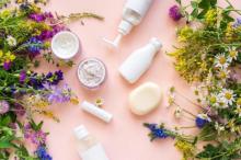 Flowers and beauty products on pink background