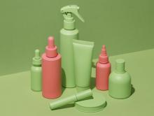 Green and orange cosmetic beauty products on green background