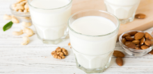 Set or collection of various vegan milk almond, cashew, on table background. Vegan plant based milk and ingredients, top view
