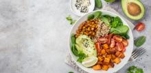 Healhty vegan lunch bowl. Avocado, quinoa, sweet potato, tomato, spinach and chickpeas vegetables salad