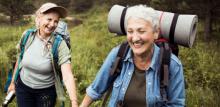 Two people hiking holding hand and smiling, sign up to Veganuary