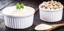 photograph of aquafaba mayonnaise in a jar next to dried chickpeas