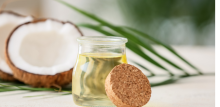 Coconut oil in a jar with coconuts in the background