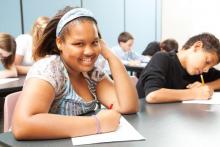 School girl smiling at a school desk 