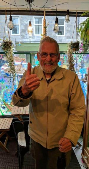 Image of person smiling with a thumbs up gesture.