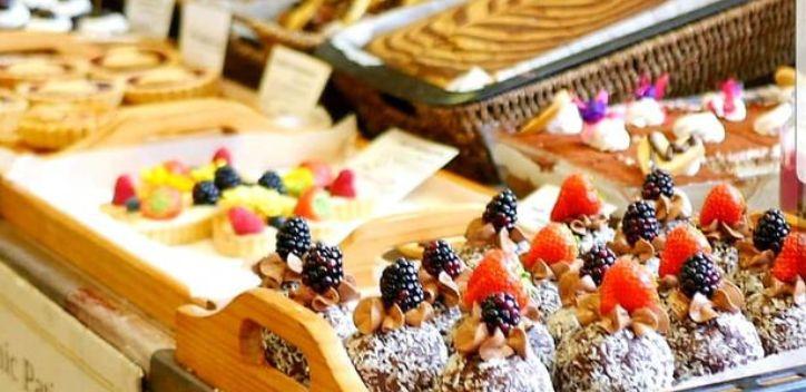 A tray of vegan desserts with more varieties in the background
