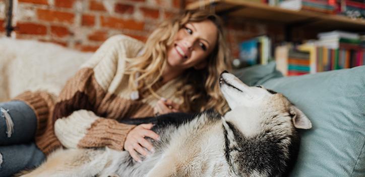 Woman sitting with her dog on the sofa 